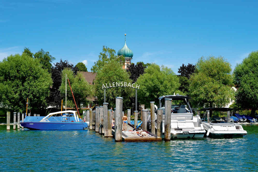 On the north bank in Allensbach, the baroque onion dome of St Nicholas' Church peeps above the treetops. A small jetty in front of it