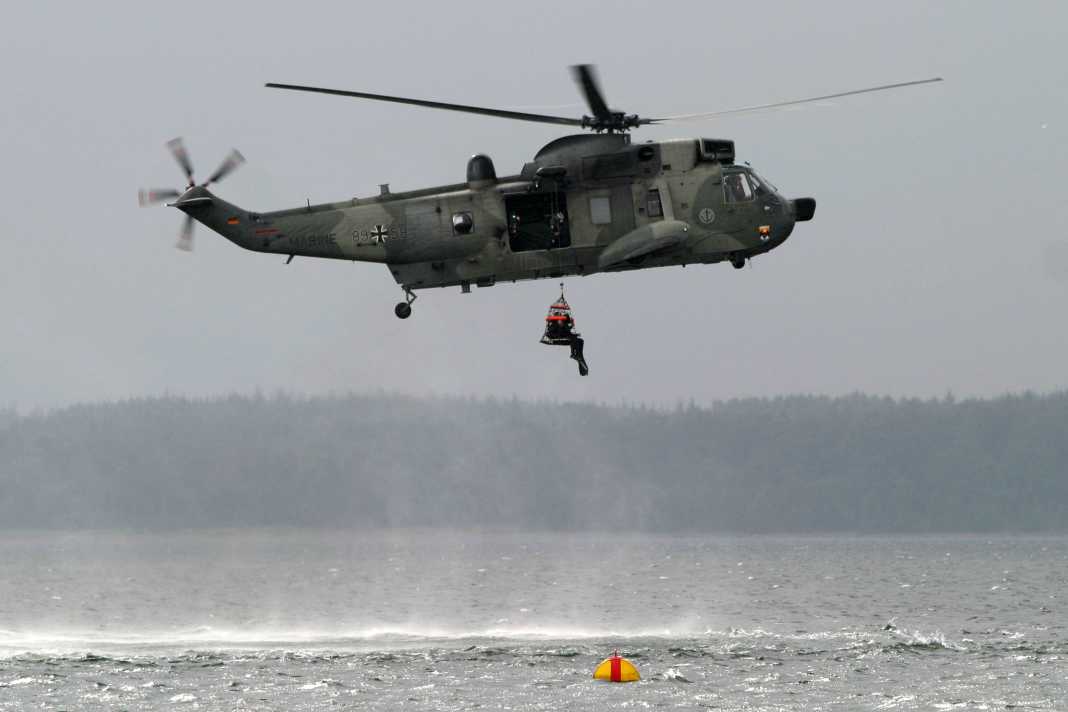 The mine divers are winched up out of the water