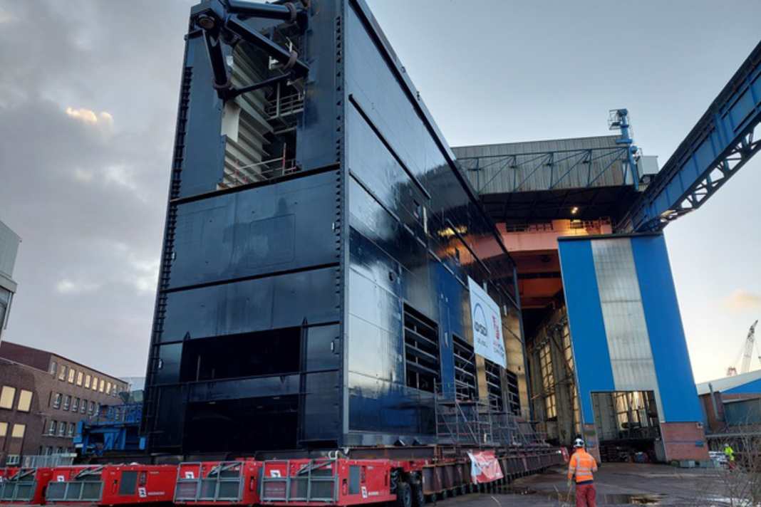 Eines der Schiebetore für die neue Brunsbütteler Schleusenkammer wird per Schwerlastmodul aus der Montagehalle gefahren.