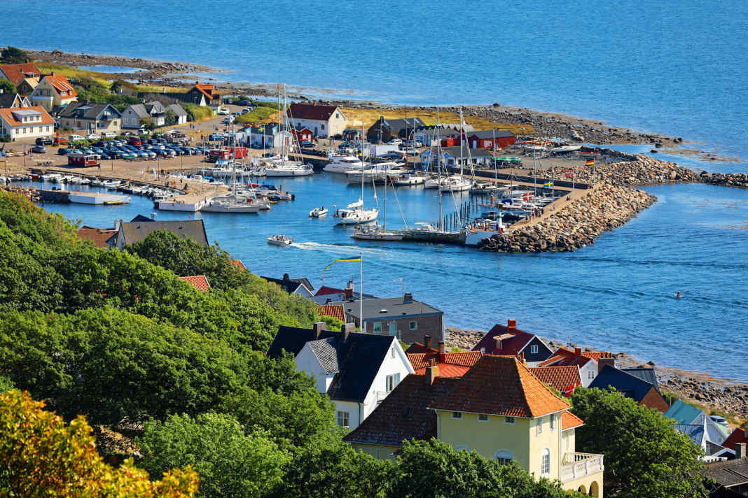 View from the wooded heights of the Kullaberg down to the harbour of Mölle. It is early afternoon. Those who arrive in the evening can look forward to a place in the packet