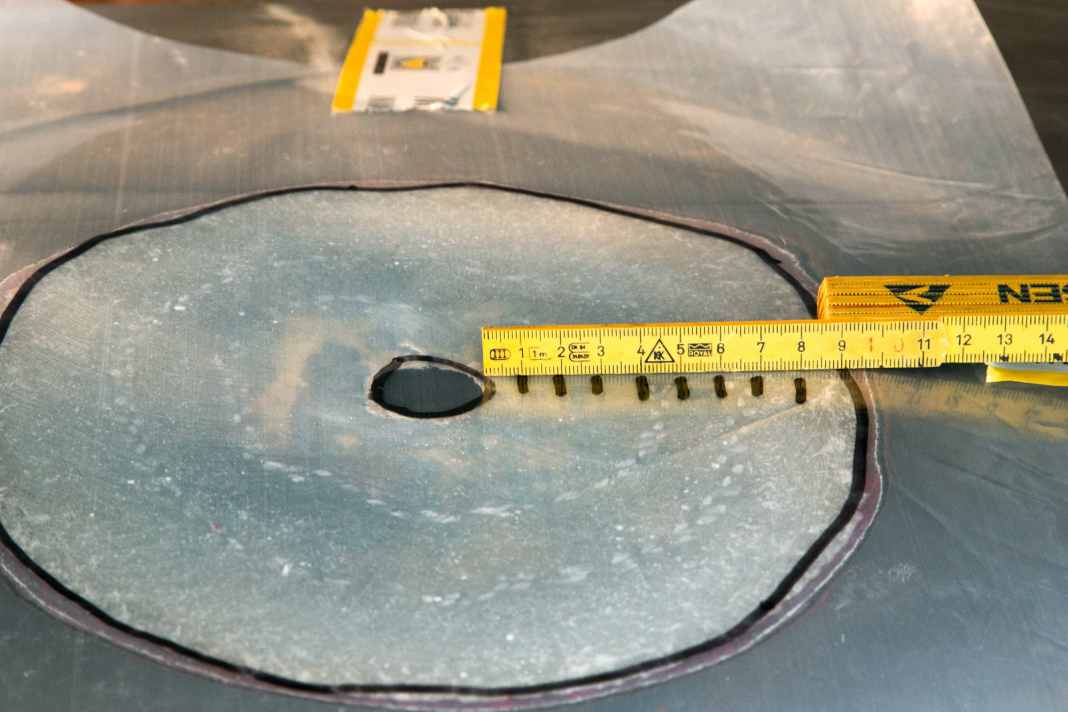Schäftung schleifen: Um das Loch wird eine Schäftung mit der zwölf­fachen Laminatstärke geschliffen, in diesem Fall etwa zehn Zentimeter. Den Umriss auf eine Folie übertragen und darauf die Größe der Glasfaserflicken anzeichnen