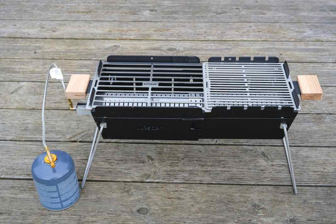Der recht kleine Knister-Grill kann durch seine raffinierte Konstruk­tion zusammengeschoben werden; das dadurch kleine Staumaß ist bordgerecht. Leider kam der Brenner im Test nicht auf Tempe­ratur, lediglich im zusammen­geschobenen Zustand wurde der Grill heiß. Das Problem ist dem Hersteller bekannt, es soll von einem defekten Gasschlauch verursacht worden sein
