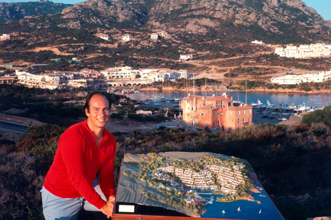 Prince Karim Aga Khan 1960 on a hill above Porto Cervo, in the background the Yacht Club Costa Smeralda which he co-founded