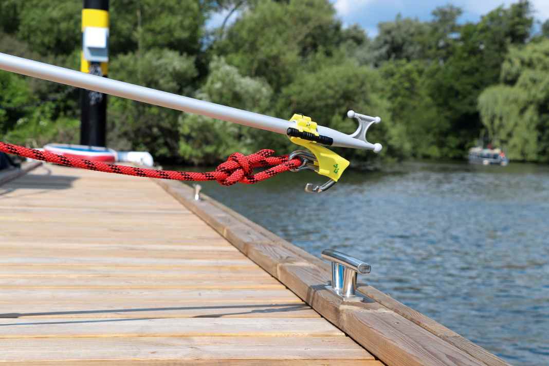 Mit dem angeknoteten Festmacher lässt sich der Karabiner in die gelbe Halterung schieben und ...
