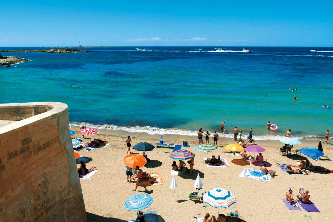 Reine Freude: Die Spaggia della Purità – „Strand der Reinheit“ –  in Gallipoli. Im Hintergrund der Leuchtturm der Isola di Sant’Andrea