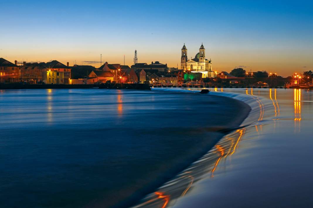 View along Athlone's weir step towards the pleasure boat jetty and the brightly lit cathedral behind it. The long exposure is deceptive: the river is anything but peaceful at this point