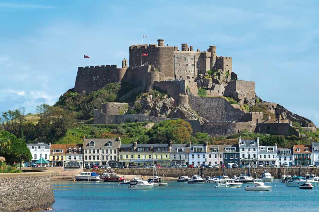 Jerseys älteste Burg Mont Orgueil Castle (um 1200 gebaut) mit dem Ort Gorey zu Füßen – eine beinahe mediterrane Postkartenidylle. Das Foto ist bei Hochwasser aufgenommen, bei Niedrigwasser fällt der Hafen vollständig trocken
