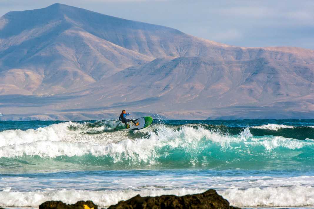 Close enough to touch: if you slice the waves at Fuerteventura's Rocky Point, the volcanic landscape of Lanzarote is always at your back.