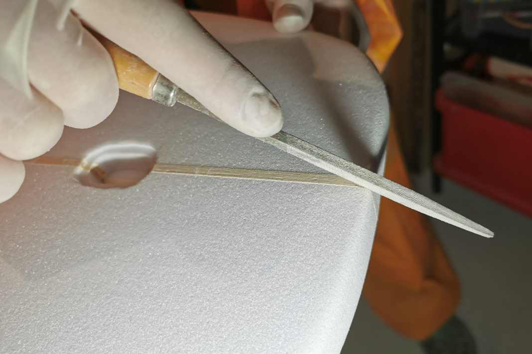 The wooden "stringer" in the centre is worked on with a small file