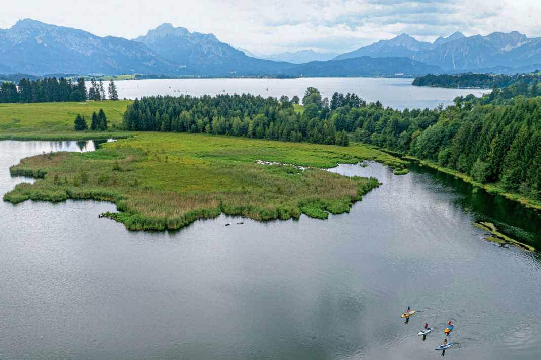 Idyllisch eingebettet liegen der Forggensee (Hintergrund) und Illasbergsee (Vordergrund) im Allgäu.
