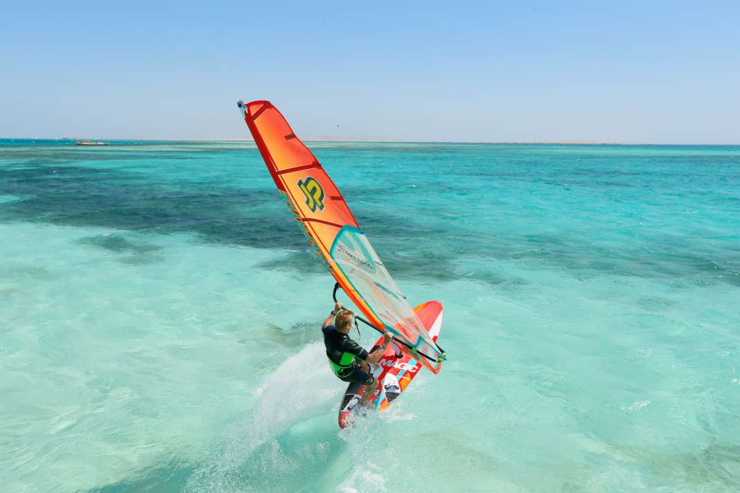 While with all other types of jibes you are aiming to gather maximum speed in a roomy wind, with tight jibes the approach tends to be half-wind. If there is a lot of wind, it can be useful to reduce the speed a little by opening the sail and applying a slight load to the stern before starting.