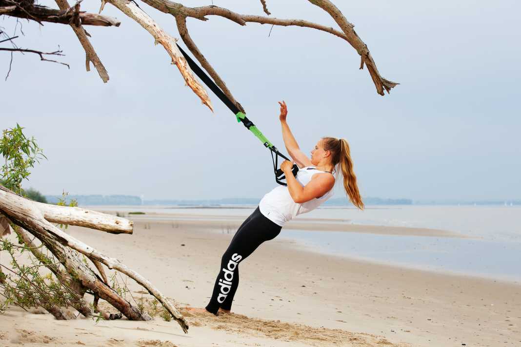Grasp both handles with one hand and bring the sling trainer to tension by slightly reclining it