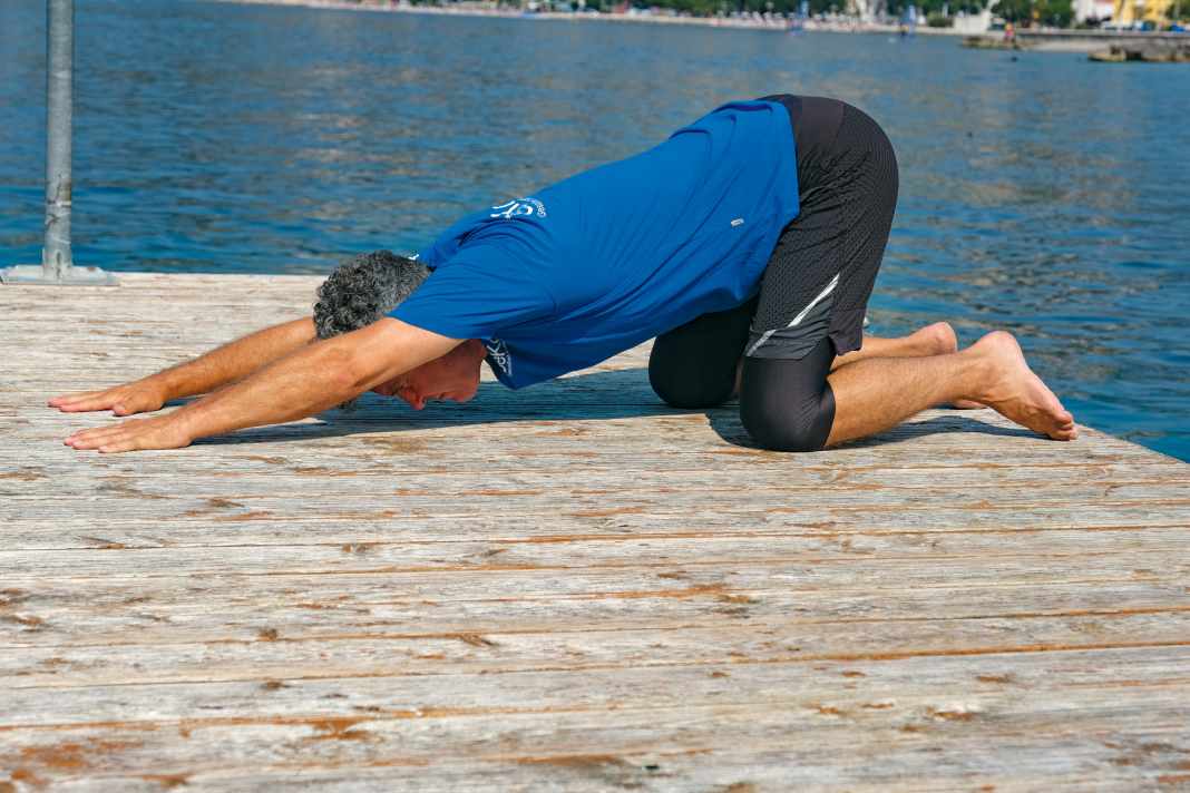 Get into a quadruped position, place both hands on the floor far in front of you