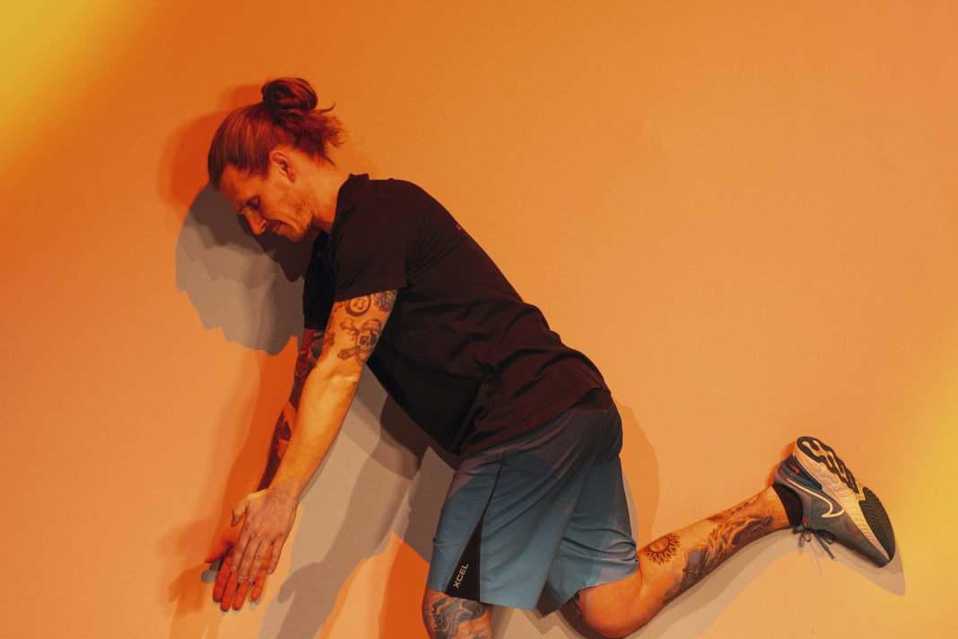 Wall Angels: Stell dich neben eine Wand, beuge dich nach vorne und hebe das an der Wand stehende Bein an. Mit gestreckten Armen suchst du gleichzeitig mit dem Hand- rücken den Kontakt zur Wand.