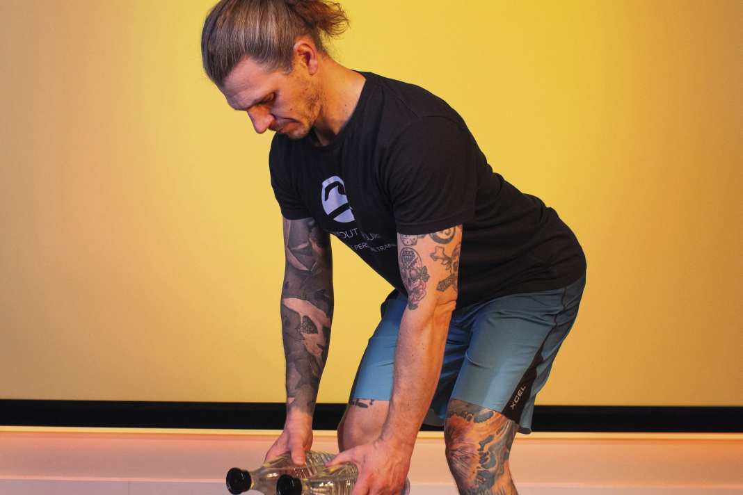Bend forwards by tilting your pelvis back and bending your knees slightly. Keep your back straight and your chest proud. Let your arms dangle loosely downwards.
