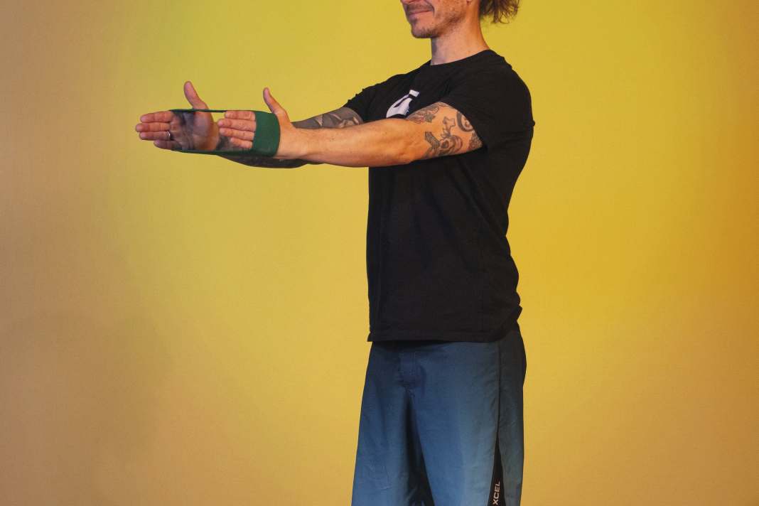 Place a loop band around your hands.  Tighten the band and move your hands as far apart as possible.  Now stretch your arms forwards, holding against the resistance exerted by the band on the back of your hands. Breathe out as you stretch.