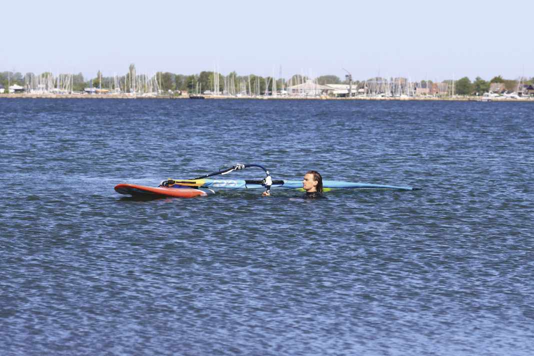 Bring into position: Firstly, position your equipment so that the bow points diagonally to windward and the mast is more or less at right angles to the wind direction. From this position, the wind can blow nicely under the sail and, with your help, get it out of the water without any problems.