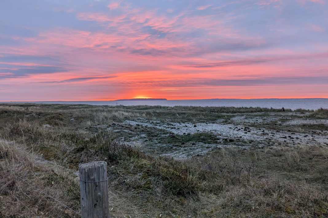 Von einigen Plätzen auf Flyvesandet kann man traumhafte Sonnenuntergänge über der kleinen Insel Æbelø ansehen