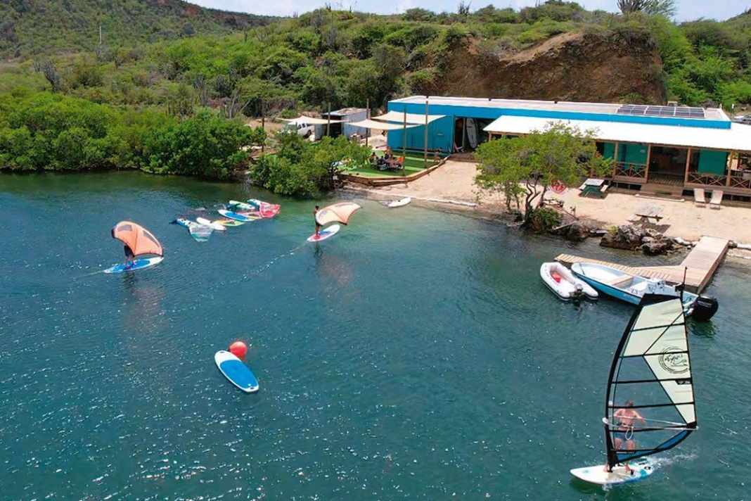 Durch die Tiefe auch sehr schön zum Foilen: Karibik-Feeling mit entspanntem Surf-Vibe machen bei Windsurfing Curaçao den böigen Wind wieder wett.