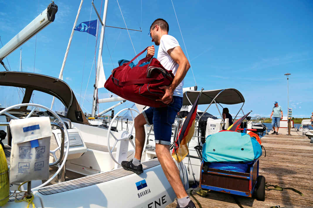 Chartersegler Nils Dreßen steigt mit viel Gepäck an Bord. Was in den Stunden zuvor so alles passierte, damit er ein sauberes und technisch einwandfreies Schiff vorfindet, ahnt er kaum