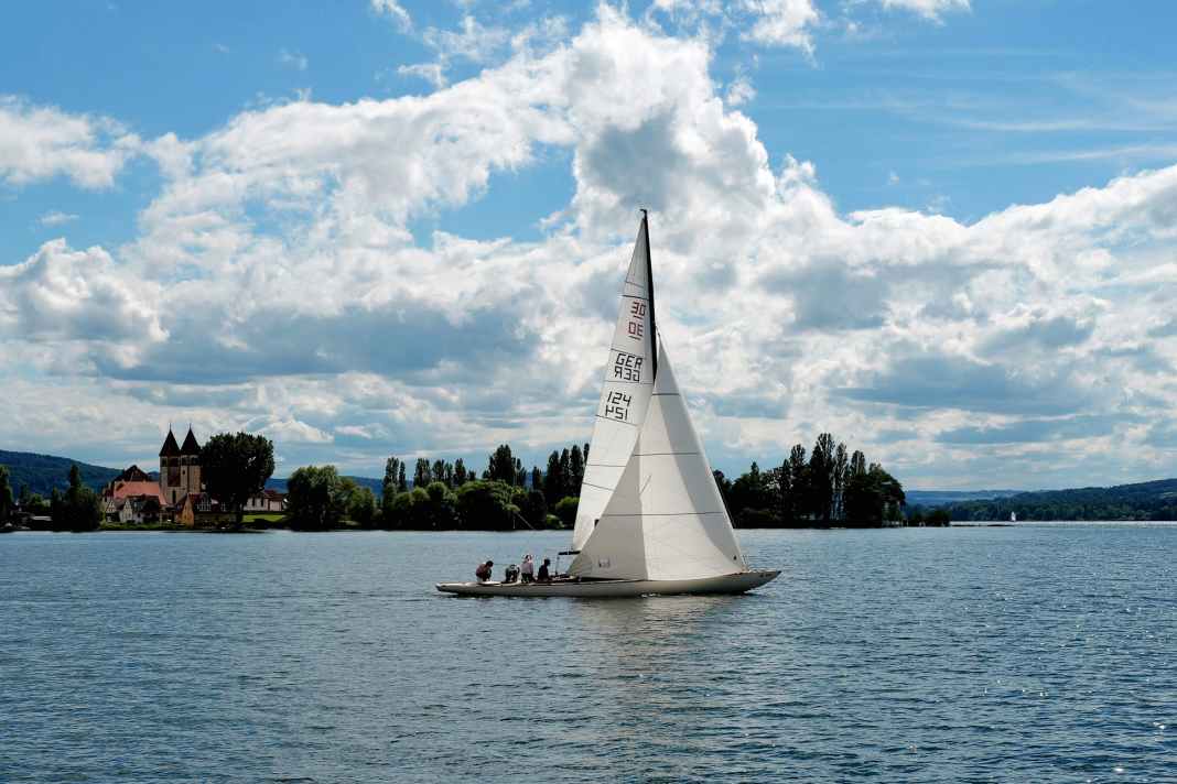 Un schärenkreuzer de 30 passe devant l'église St. Peter und Paul à Niederzell, à la pointe nord-ouest de Reichenau