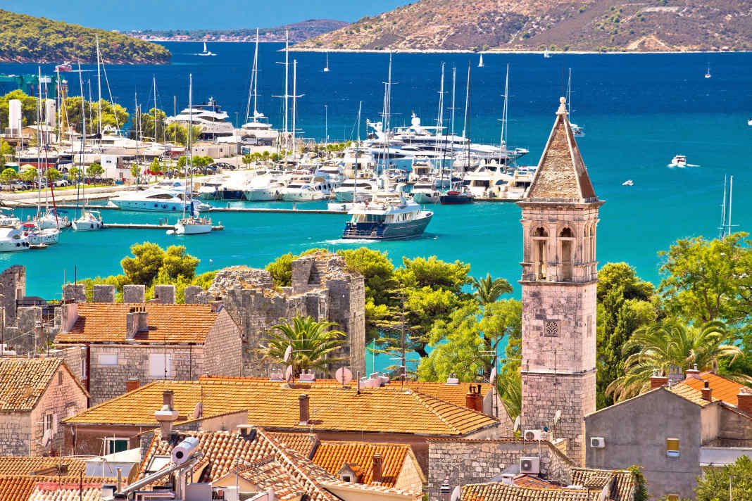 La vieille ville de Trogir, classée au patrimoine de l'Unesco, est également un lieu d'étape qui vaut la peine d'être visité par les équipages de charter. Sur la photo de gauche, les pontons de la marina de Trogir, à l'arrière-plan le passage vers la mer Adriatique ouverte.