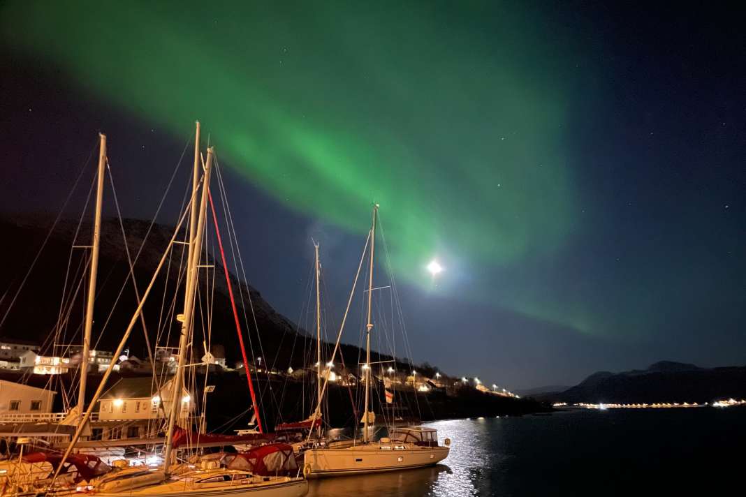 Eine sternenklare Nacht mit Sonnenaktivität beschert Polarlichter im Hafen von Hamnnes. Apps helfen bei der Vorhersage.