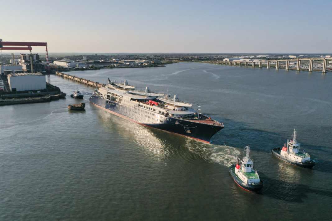 Tugboats pull the half-finished "Orient Express Corinthian" out of the dock.