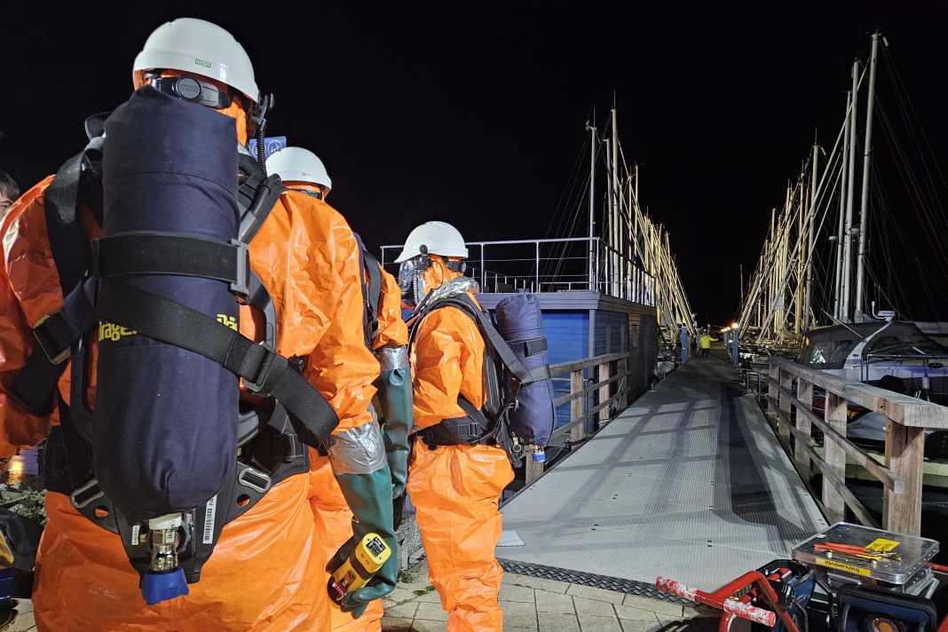 Une image qui ne va pas ensemble : Les pompiers du train de matières dangereuses en combinaison de protection contre les acides sur la passerelle de Fehmarn