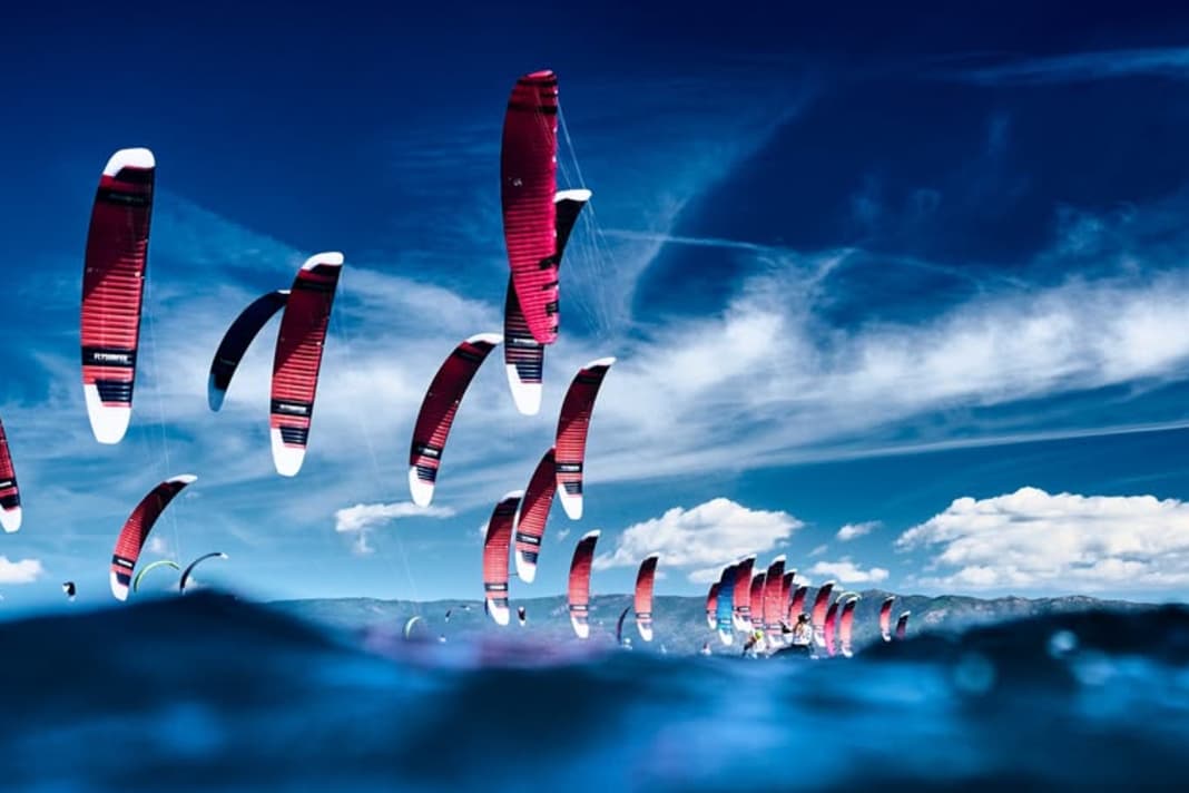 Das Bild zum Kitesport, der Himmel und Wasser miteinander verbindet.