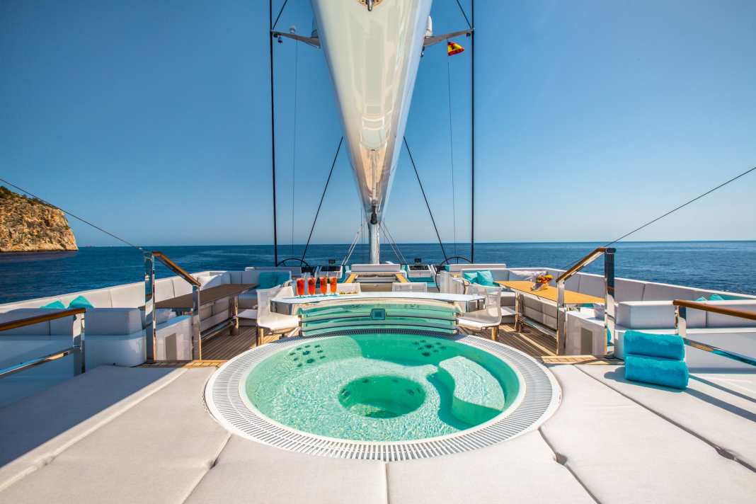 Flybridge : pendant que le capitaine s'occupe du réglage des voiles à l'avant du poste de pilotage, les invités profitent de la vue au bar jacuzzi. Il n'y a pas de meilleur endroit pour boire son cocktail - selon la gîte, il est également possible de barboter pendant le voyage.