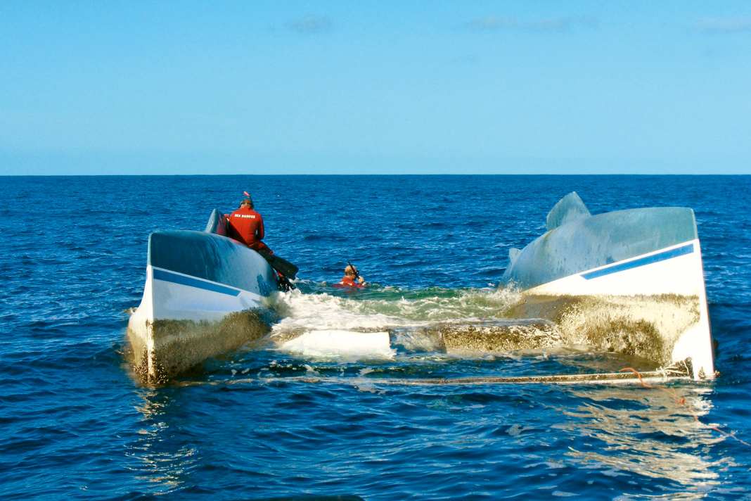 Ein vor Südafrika gekenterter Kat, die Crew kann sich auf den Rümpfen sichern