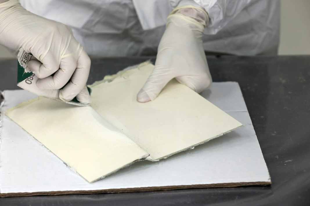 The repair area is sanded over a large area with 80-grit paper until the surface is evenly matt