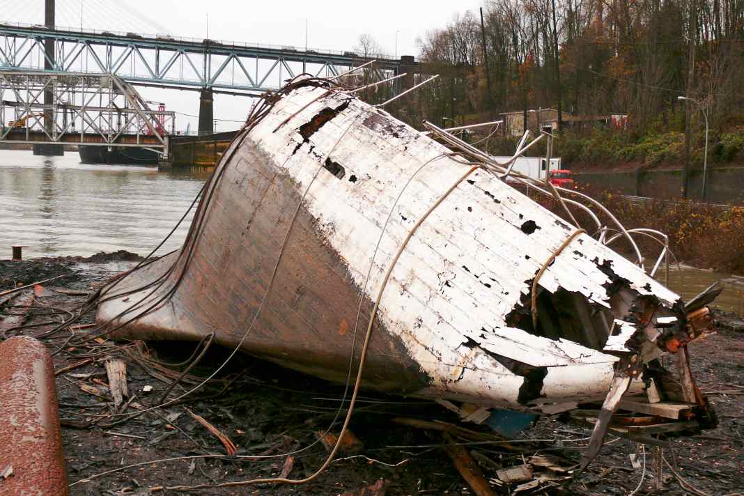 After the salvage operation, the hull of the once proud twelve-person vessel lies on land like a beached whale