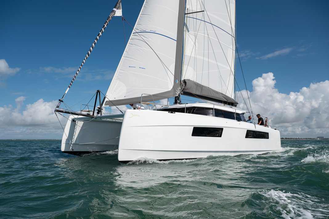 With corners and edges. The hull has pronounced chines just above the waterline. This creates volume in the hulls and narrows the waterline.