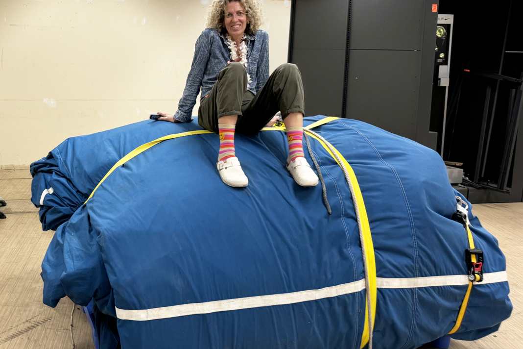 Angela Abshier sitzt auf einem tonnenschweren Segelpaket.
