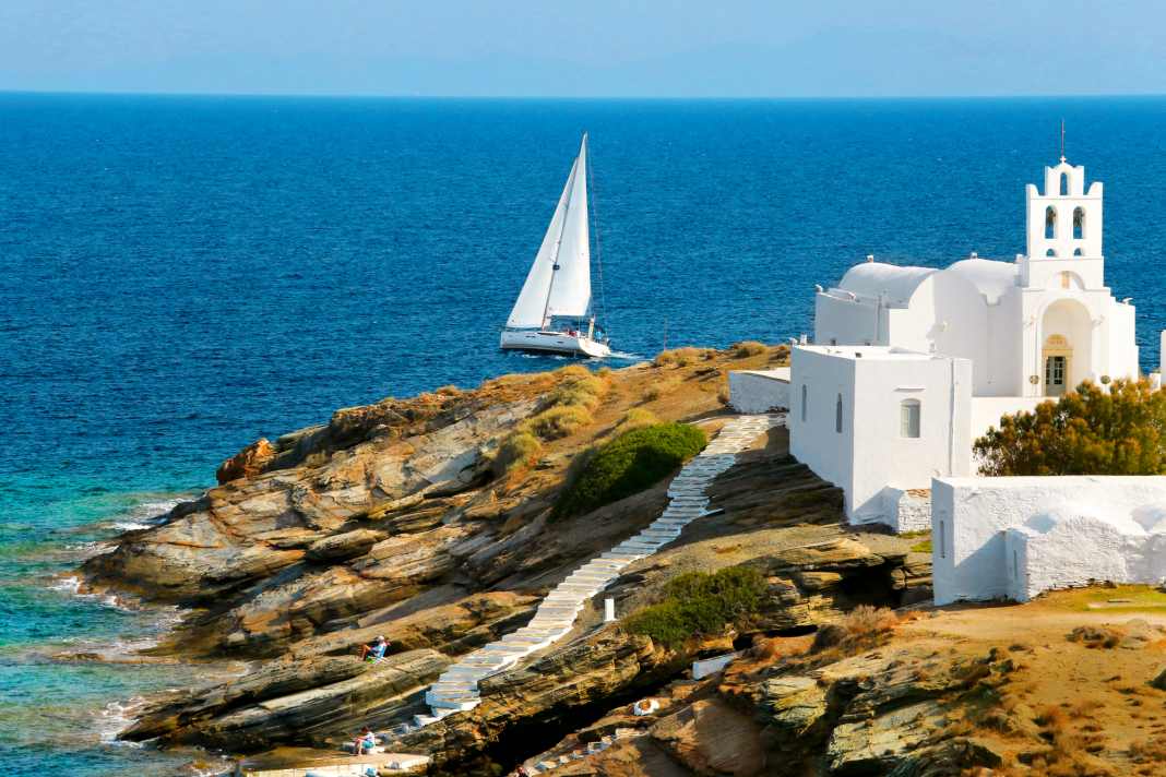 Un yacht navigue le long d'une chapelle sur la côte sud de l'île de Sifnos. Il y a assez de criques et de sites pour trois jours.