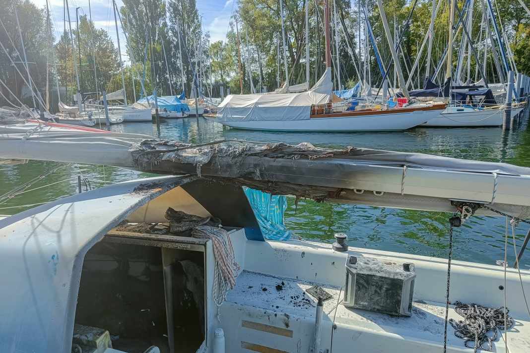 The Bente 24 after the fire. The charred boom cover gives an idea of how high the flames blazed from the companionway. The portable battery in the cockpit does not appear to be the cause of the fire