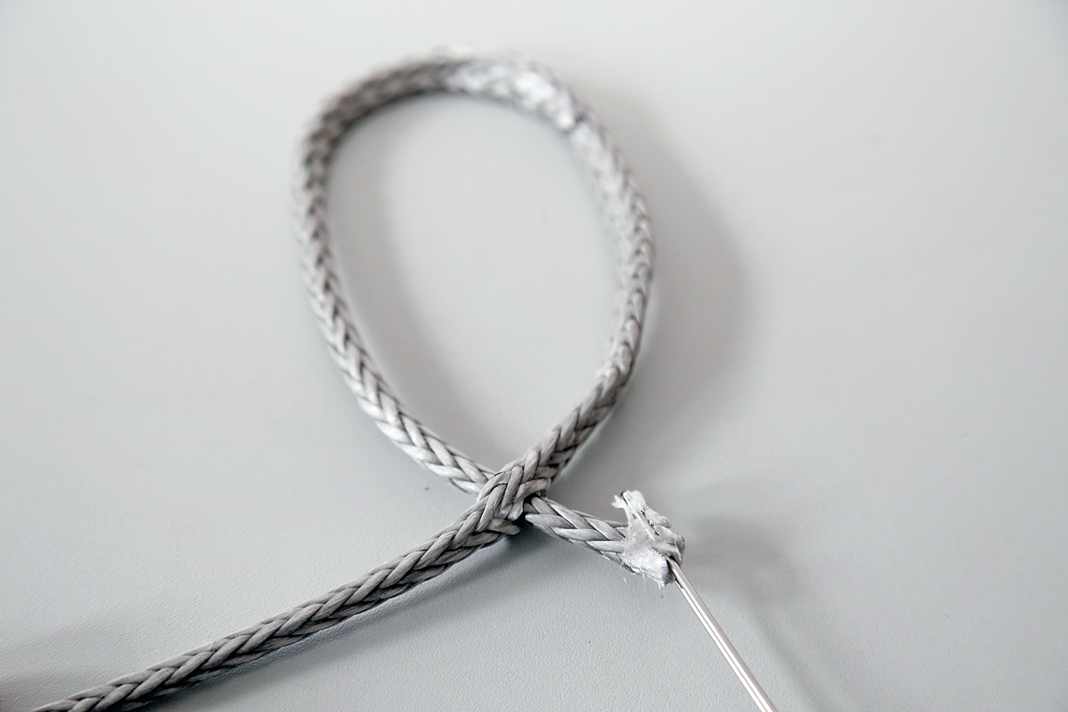 It is easier to make the first cut if you compress the rope beforehand - regardless of whether you are working with a wire loop or a fid