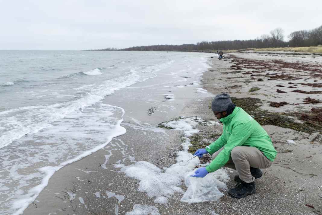 In Kühlungsborn, Dr Julios Kontchou, Greenpeace, takes a sample of the sea foam to analyse it for PFAS.