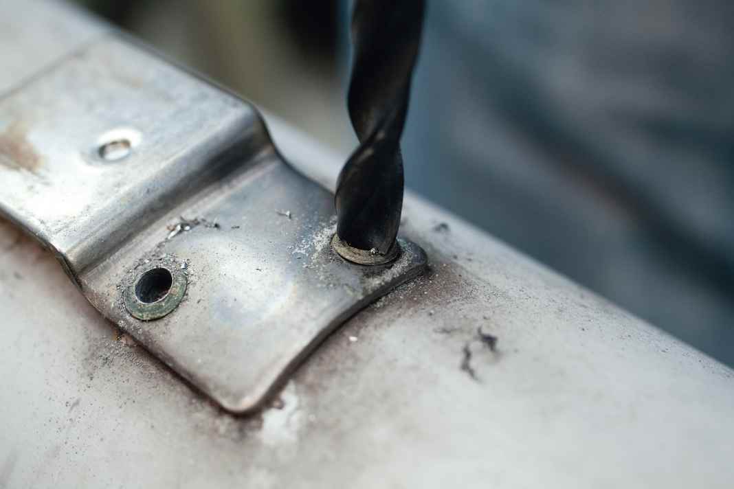 The head can be removed using the drill bit, which should be slightly larger than the rivet hole