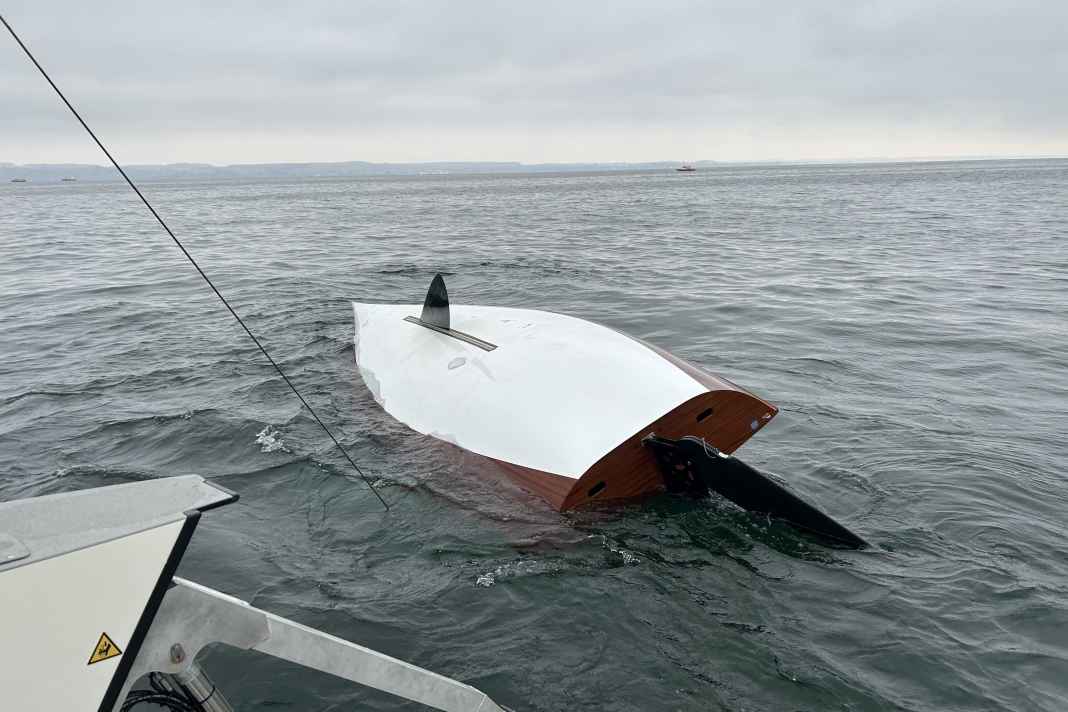 Der gekenterte 15er-Jollenkreuzer, der Mast steckt im Grund