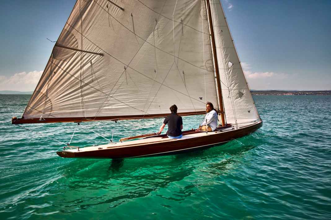 L'immense grand-voile à gaffes avec sa bôme dépassant largement de la poupe marque la silhouette de l'antique voilier de course.