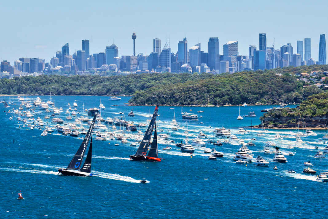 The 100-foot maxis "Master Lock Comanche" and "LawConnect" are flanked by an armada of spectators.