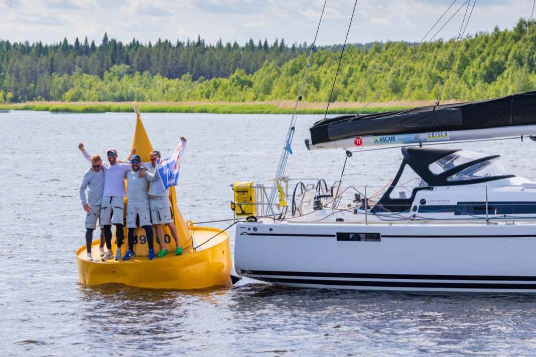 The "Lightworks" crew led by Michael Höfgen celebrates crossing the finish line at the MidsummerSail on the legendary yellow Töre buoy.