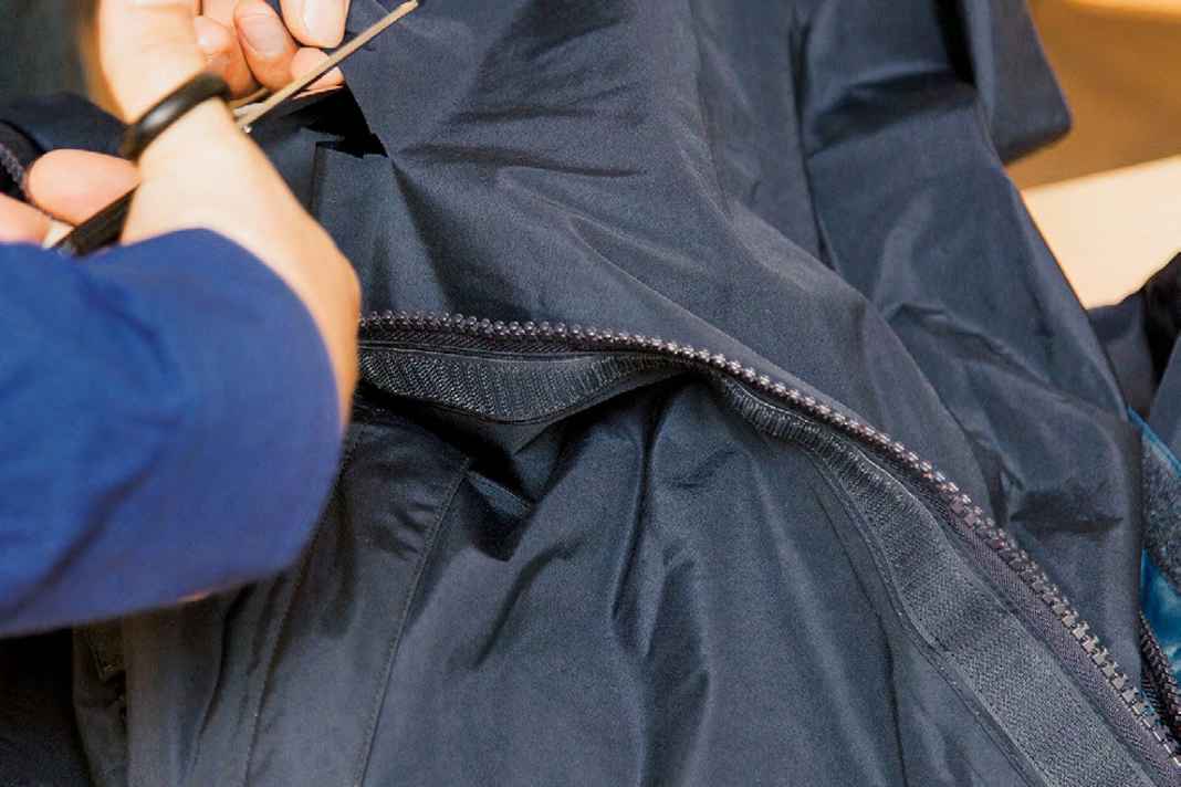 La bavette derrière la fermeture éclair du pantalon ne contribue guère à l'étanchéité. Ici, on découpe le patch correspondant