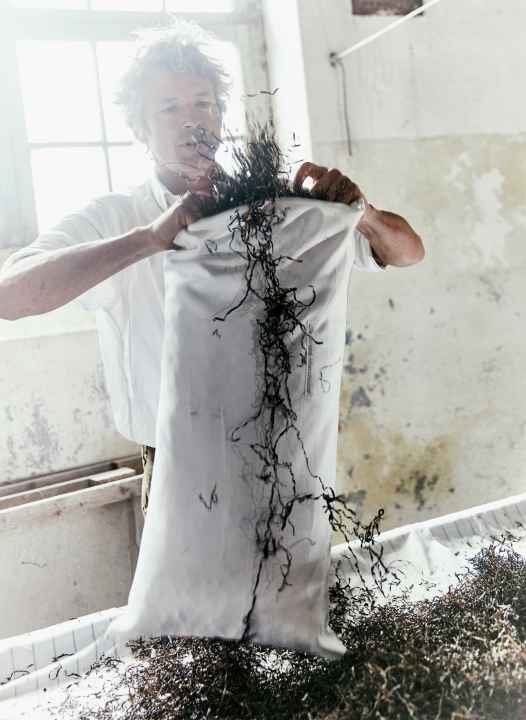 Kristian Dittmann realizza uno dei suoi cuscini di seagrass imbottiti a mano presso la Strand-Manufaktur