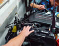 Das einlaminierte Motorfundament bekommt eine Verstärkung aus Stahl. Im ausgeräumten Cockpit hat das Mechanikerduo mit dem neuen Sechszylinder leichtes Spiel.