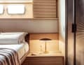 Lots of wood: the strictly parallel groove structure of the ceiling panels is echoed by the fronts of the bedside table and the sliding window panels