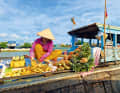 Frisch für die Touristen: Auf einem der schwimmenden Märkte im Mekong-Delta schneidet eine Händlerin Ananas für den Verkauf